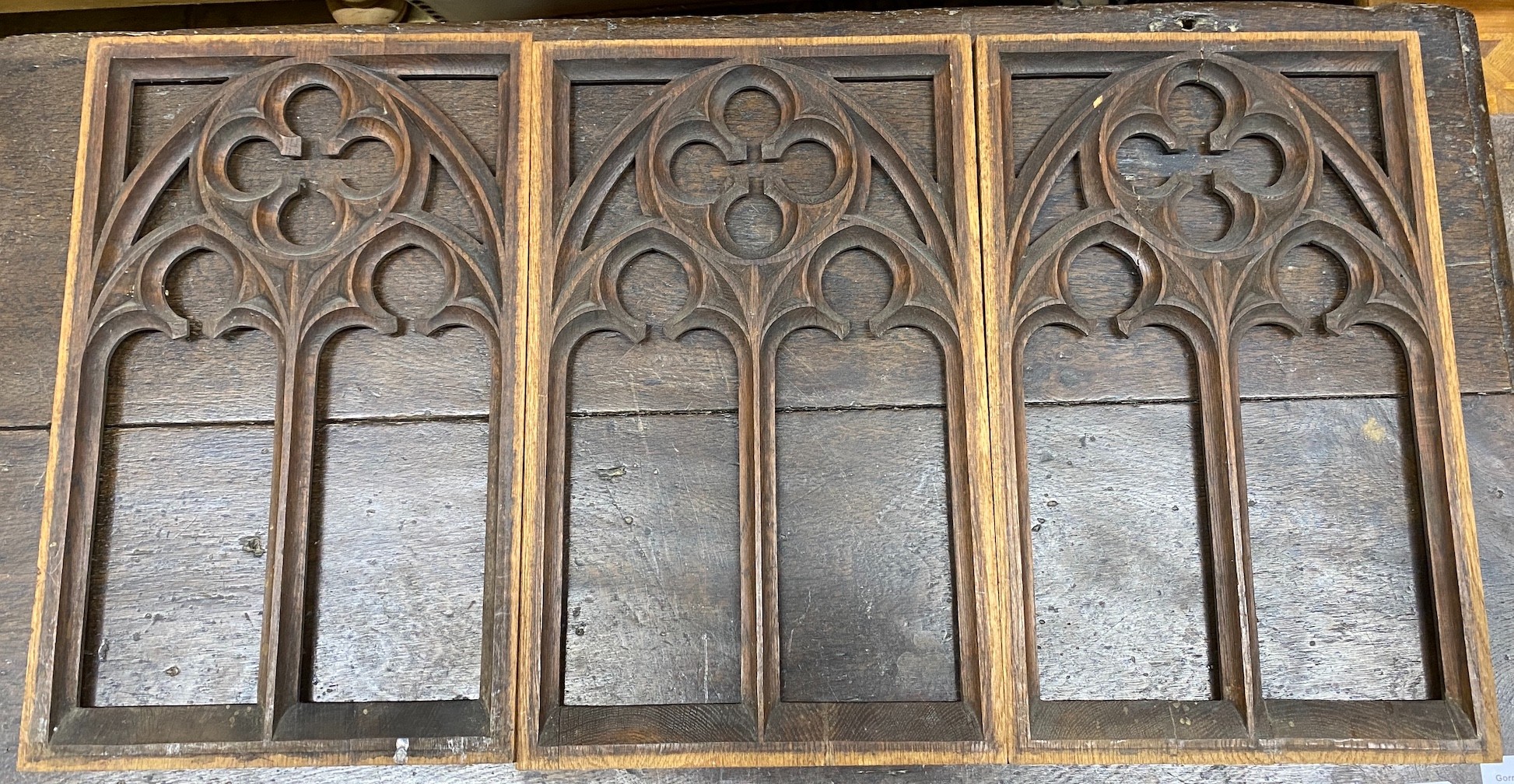 Three rectangular pierced oak gothic style panels, each width 28cm, height 45cm